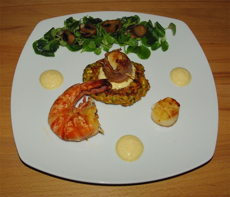 Trio von Meeresfrüchten auf Karotten-Zucchini-Puffer an karibischem Dip
